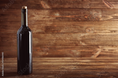 Wine bottle with cork on wooden background