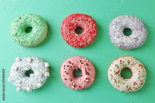 Delicious donuts on color background