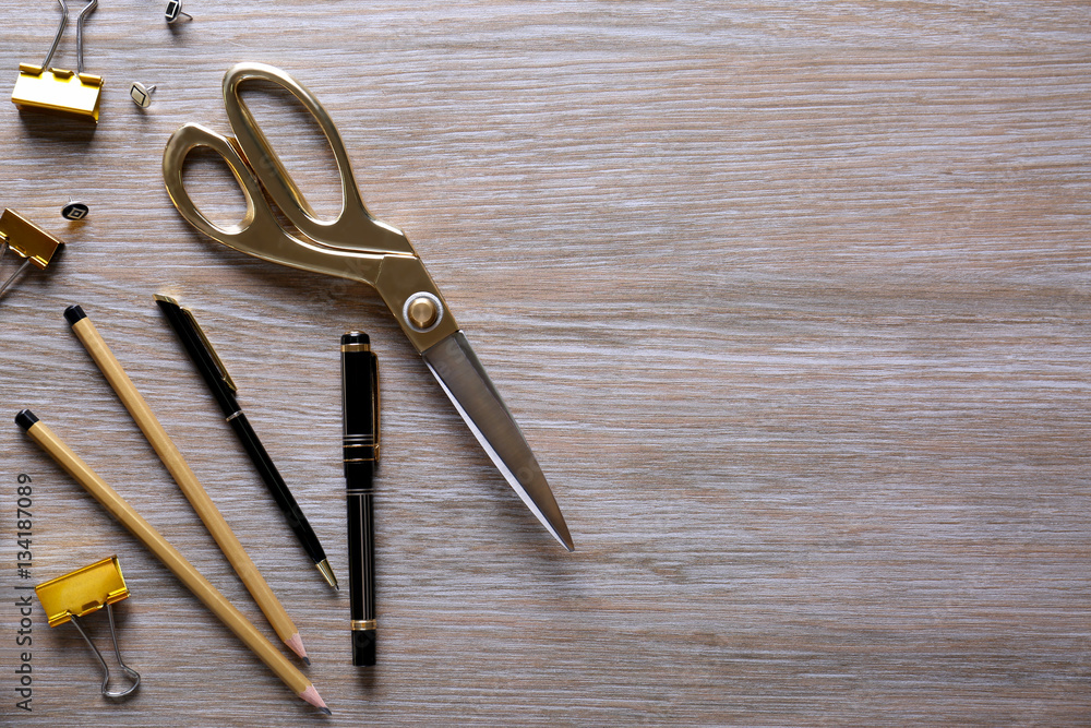 Flat lay of golden stationery on wooden background Flat lay of golden stationery on wooden background