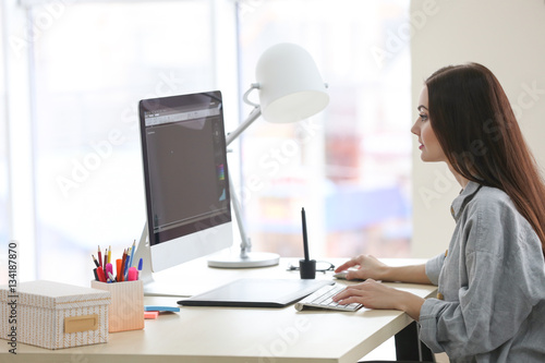 Young female designer worki...