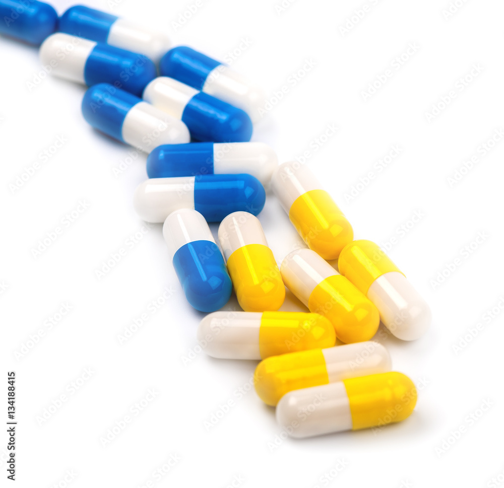 yellow and blue pills on a white background yellow and blue pills on a white background