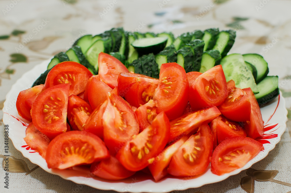 sliced tomatoes and cucumbers lie on a plate, close-up sliced tomatoes and cucumbers lie on a plate, close-up