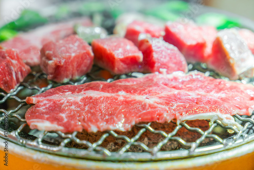 Japanese style Raw fresh beef on hot barbecue grill .
