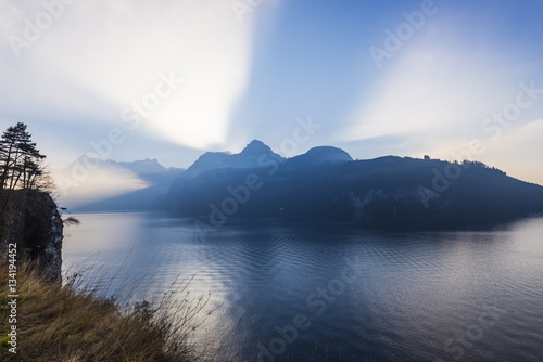 Alps of central Switzerland. Grand game of light and shadow. Sunlight sat behind a mountain ridge. Rays of light pierce the. Extra wide lens