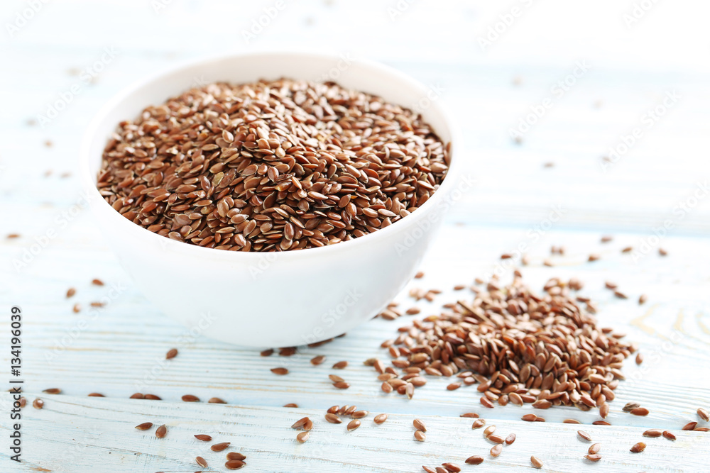 Brown flax seeds on white wooden table Brown flax seeds on white wooden table