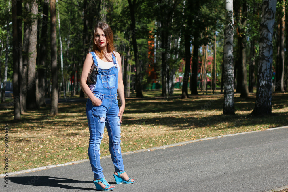 Woman in overalls standing in the park
