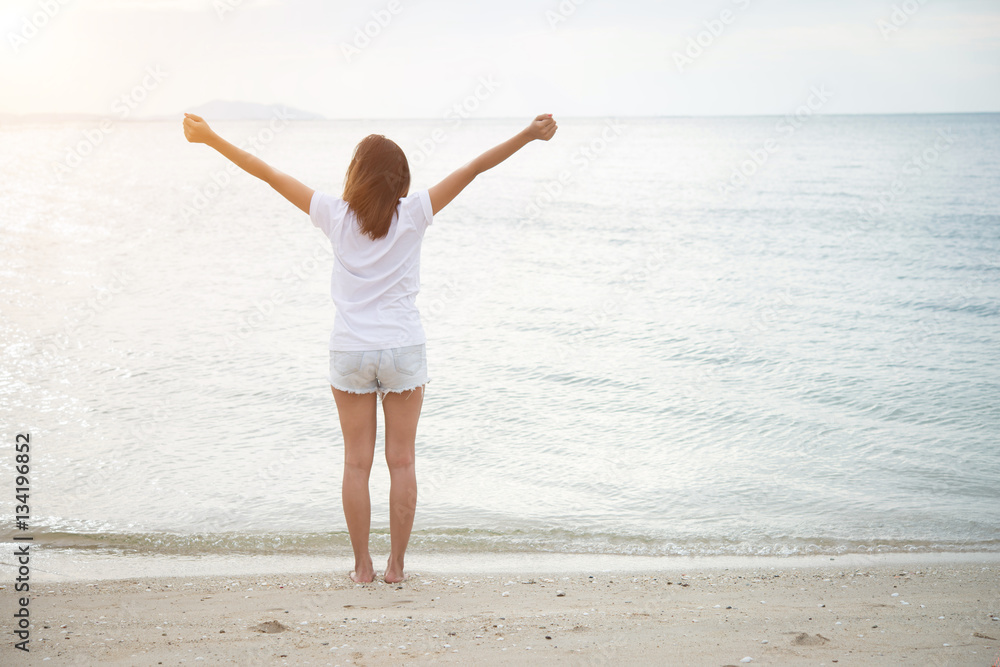 Rear of young woman standing stretch her arms in the air on the Rear of young woman standing stretch her arms in the air on the