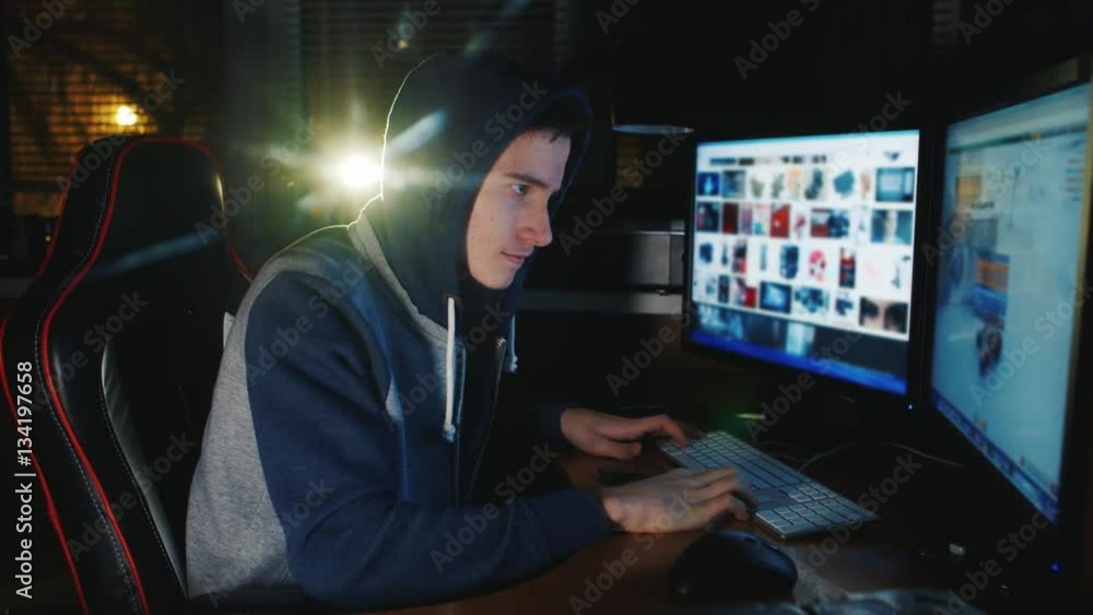 Teenager in the hood playing computer games late in the evening. Game dependence among children Teenager in the hood playing computer games late in the evening. Game dependence among children