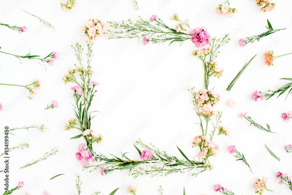 Wreath frame made of pink and beige wildflowers, green leaves, branches on white background. Flat lay, top view. Valentine's background Wreath frame made of pink and beige wildflowers, green leaves, branches on white background. Flat lay, top view. Valentine's background