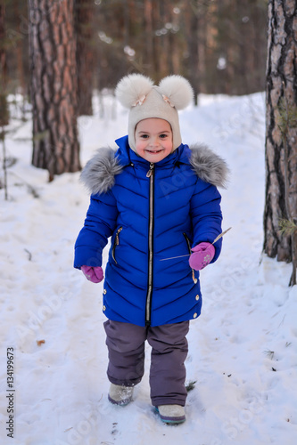 child walks in the forest park in the winter