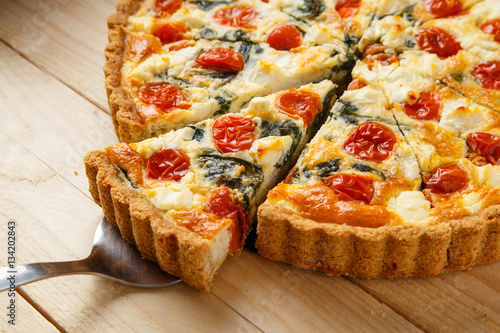 Vegetarian homemade pie, Quiche with tomatoes, spinach and feta cheese.