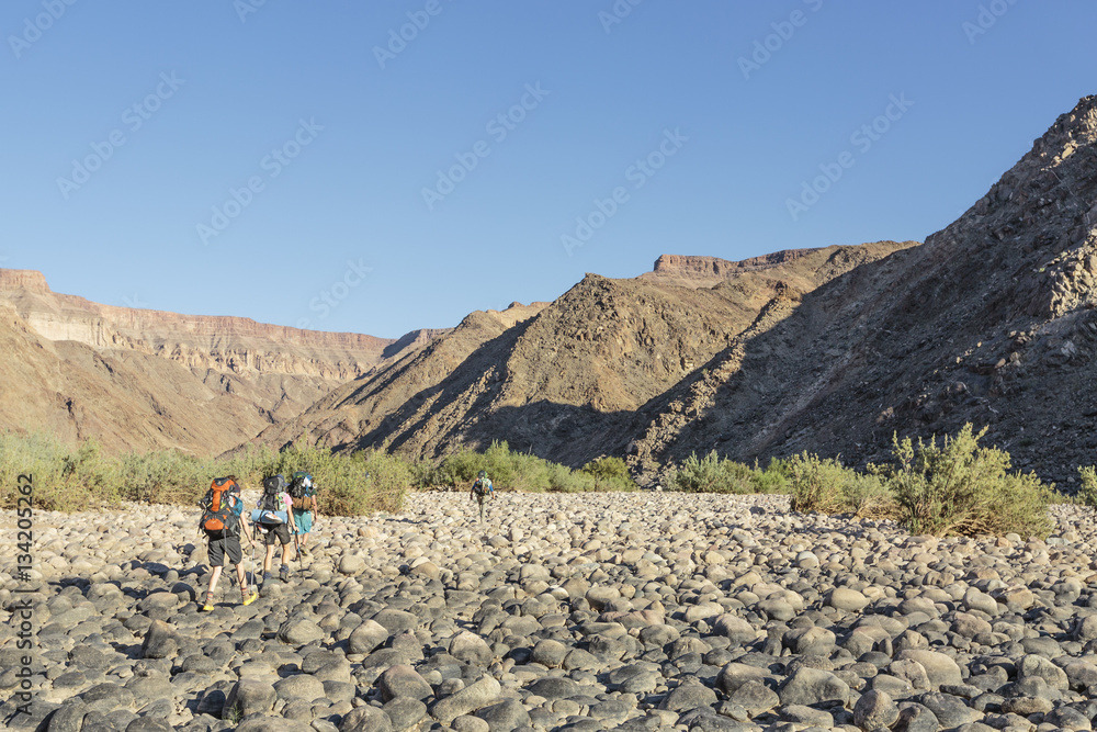 Wandergruppe läuft im steinigen Flussbett des Fish River