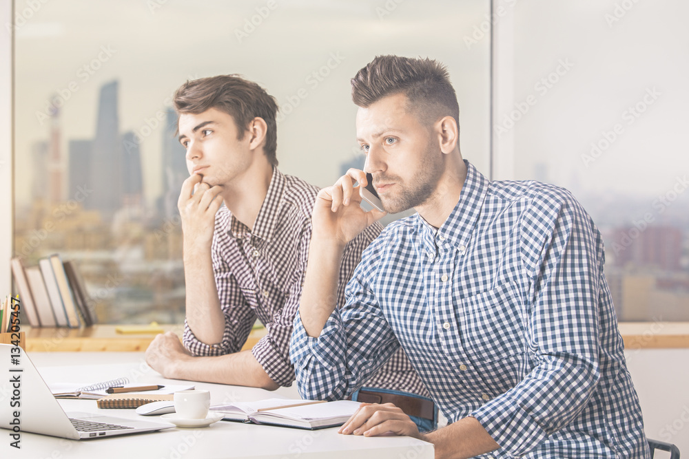 Males talking on phone at workplace Males talking on phone at workplace