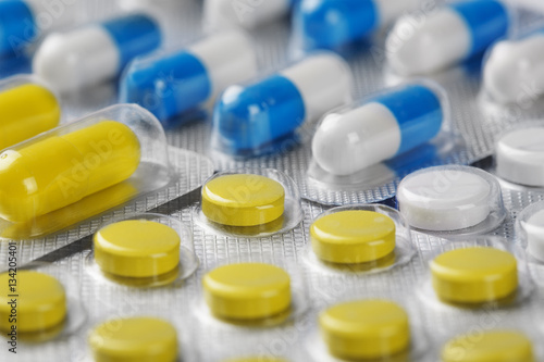 Boxes with yellow medical pills and blue-white pills