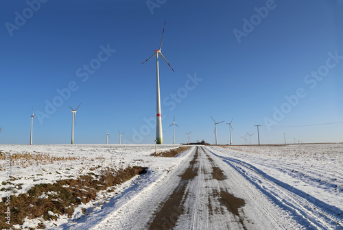Windmill generator in wide yard / Yard of windmill power generatorunder blue sky, shown as energy industry concept © leomalsam