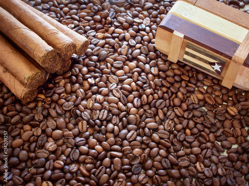 Background from coffee grains with the Cuban cigars and a box for storage of accessories photo