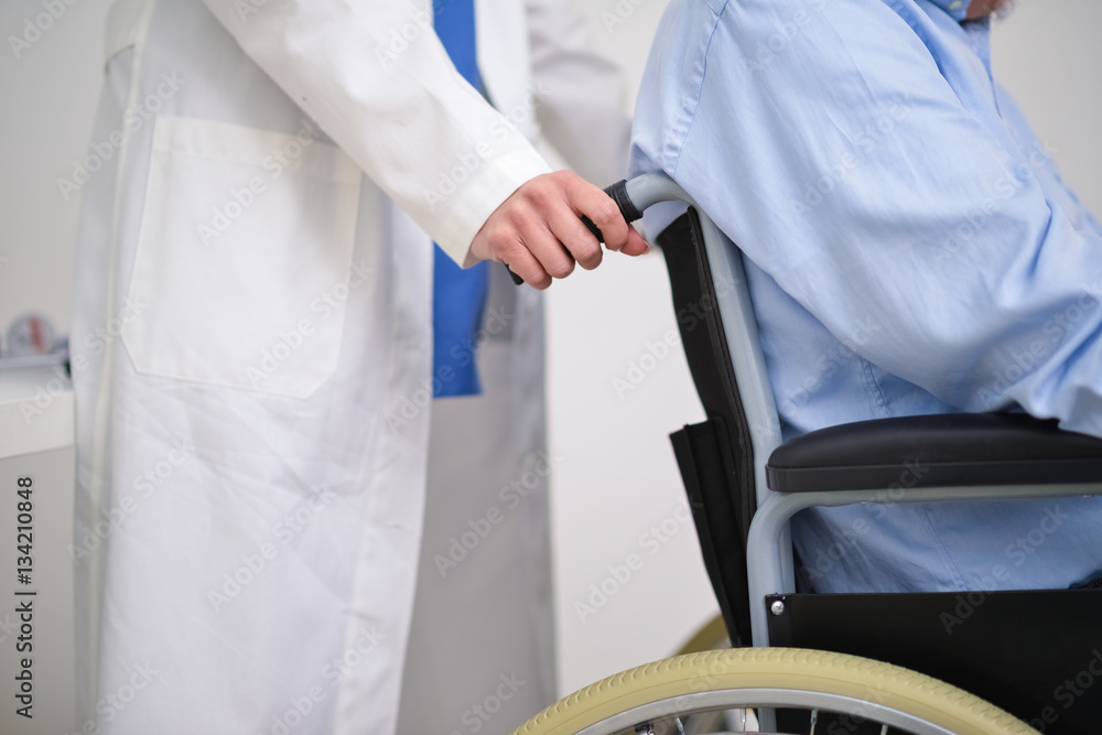 Nurse pushing a patients wheelchair Stock Photo | Adobe Stock