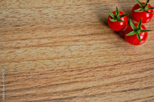 Fototapeta Naklejka Na Ścianę i Meble -  Closeup of ripe cherry tomatoes on a wooden table