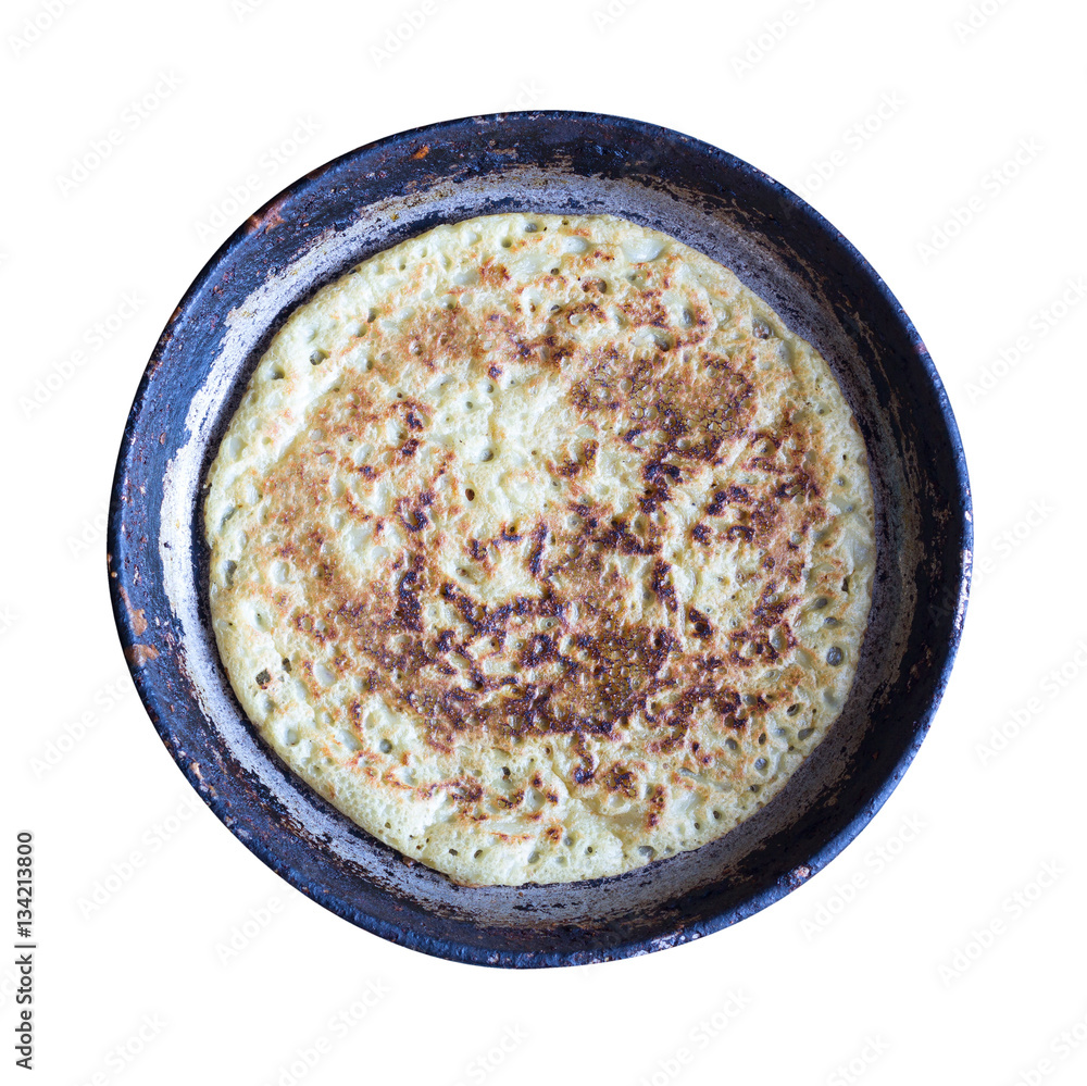 hot pancake on an old cast-iron frying pan isolated on white background, top view hot pancake on an old cast-iron frying pan isolated on white background, top view