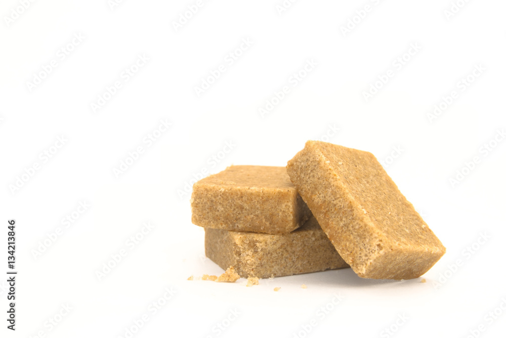 Three pieces of chicken stock cubes with some crumbs arranged on a white background