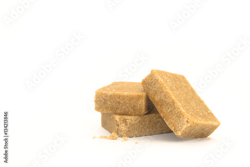 Three pieces of chicken stock cubes with some crumbs arranged on a white background