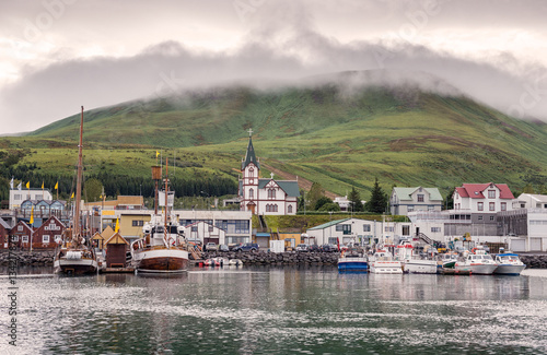 Husavik, Iceland - Fishing boats moored at harbour in subdued li photo