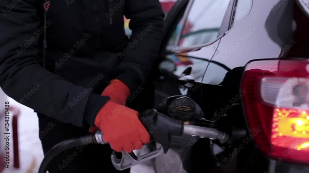 Man pours gasoline into the car Man pours gasoline into the car