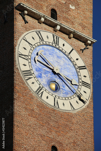 ancient clock tower with brick wall in the city europe photo