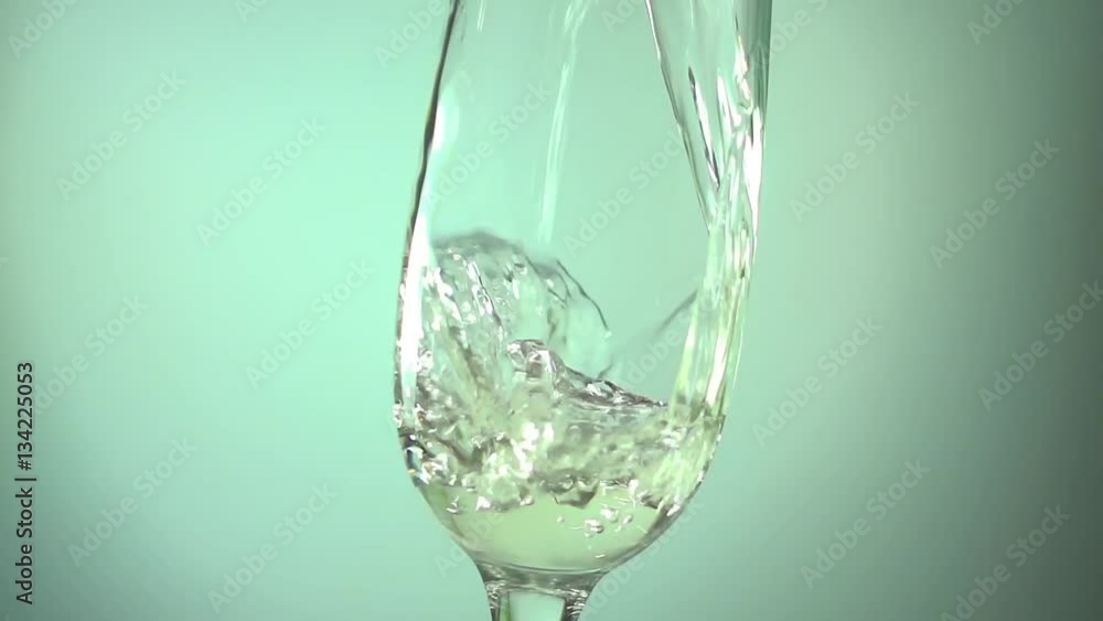 Champagne pouring into a glass on light blue background, slow motion hd video Champagne pouring into a glass on light blue background, slow motion hd video