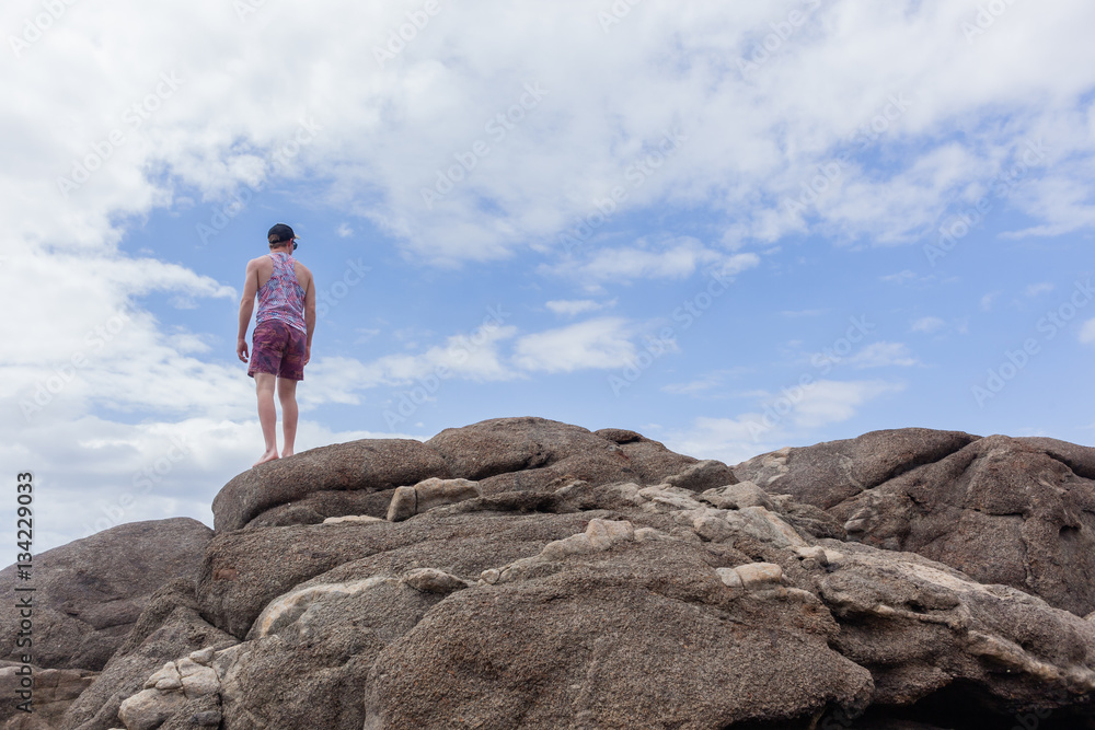 Man Looking Ocean Beach Rocks Sky