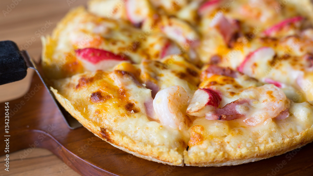 Close up of delicious fresh pizza with seafood on wooden table Close up of delicious fresh pizza with seafood on wooden table