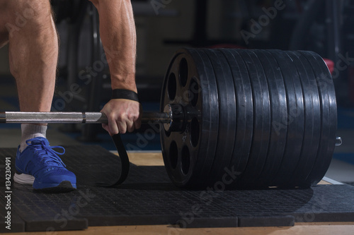 Sports background. Young athlete getting ready for weight lifting training.