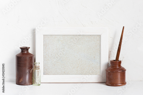 Empty white wooden frame and inkstands photo