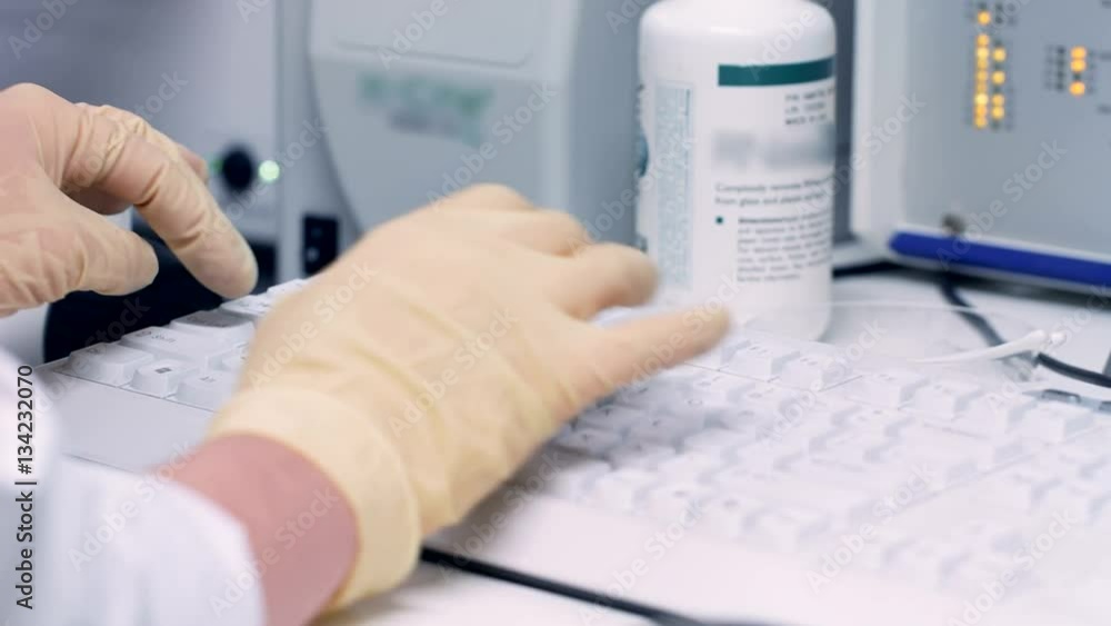 Hands scientist scoring data to a computer in laboratory Hands scientist scoring data to a computer in laboratory