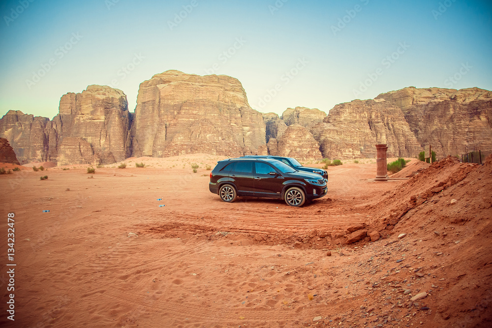 Black jeep car in the desert near the mountains in Petra, Wadi Rum. Jordan