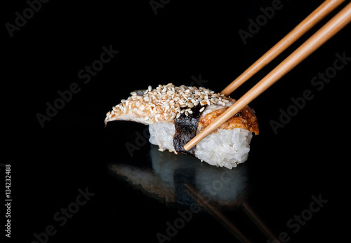 one sushi roll is on a black background with reflection. Rice wr