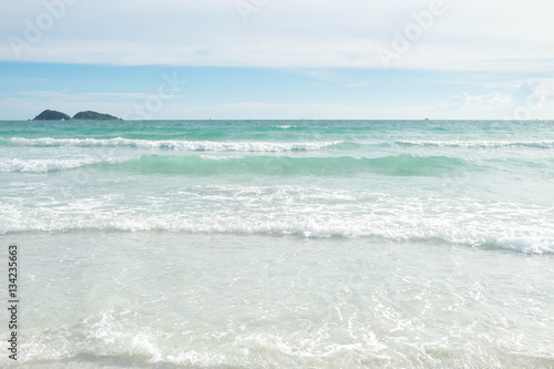 Soft wave of blue and green ocean sea on sandy beach with bright sky on sunshine day. Background.