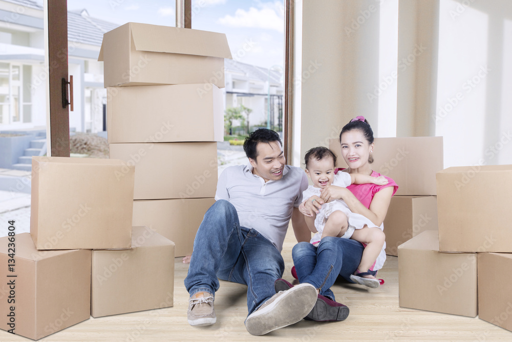 Happy family sitting on the floor with boxes Happy family sitting on the floor with boxes