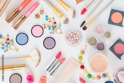 Colorful make up and brushes products flat lay scene on white background