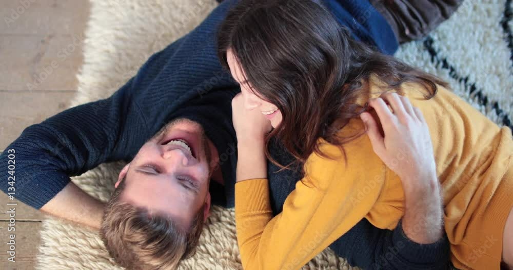 Couple lying down on rug in new home Couple lying down on rug in new home