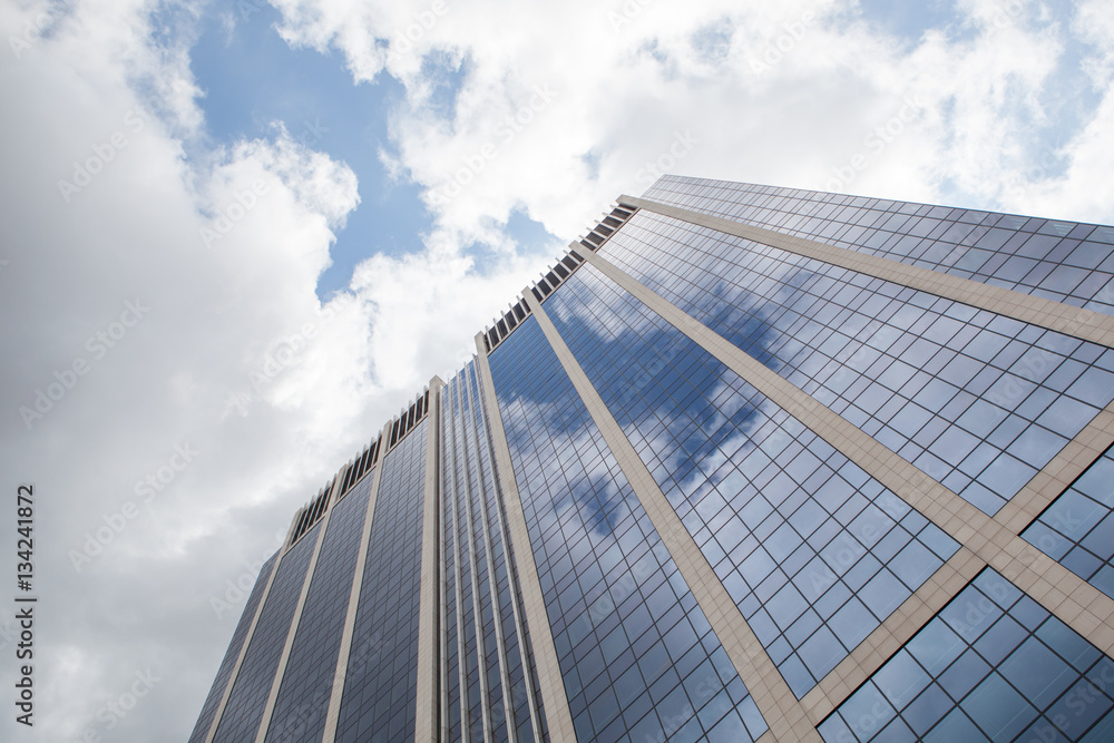 clouds reflected in windows of modern office building clouds reflected in windows of modern office building