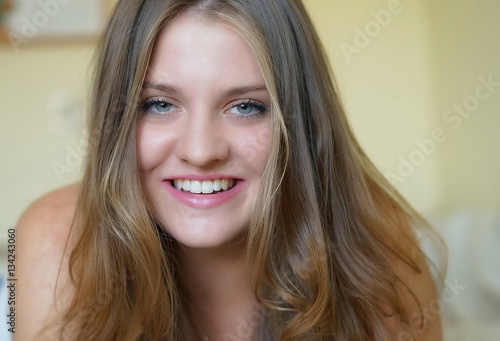 portrait of a young beautiful smiling girl with green eyes and long blond hair 