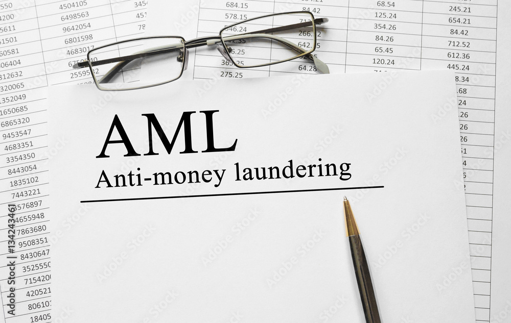 Paper with Anti-money laundering AML on a table Paper with Anti-money laundering AML on a table