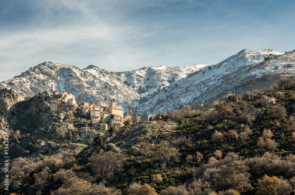 Village of Speloncato in Corsica with snow covered mountains