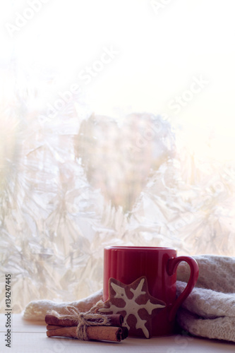 hot power of love/ warming drink in a red mug thawed frozen window in the form of a heart symbol