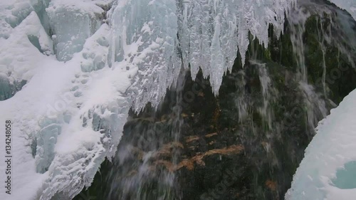 Sliding fottage of a waterfall in the winter with icicles photo