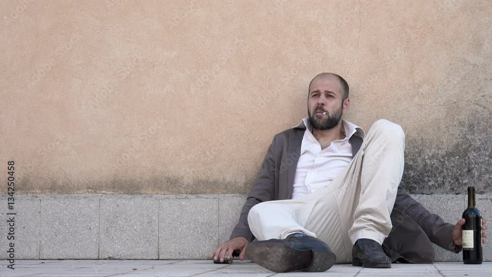 drunk business man sit on the floor smoking a cigarette drunk business man sit on the floor smoking a cigarette