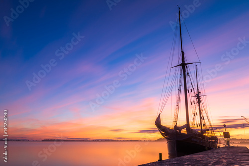 Fototapeta Naklejka Na Ścianę i Meble -  Docked sailing boat on the lake at sunrise. 