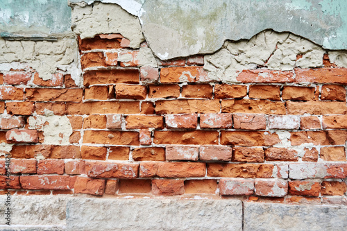 brickwork of red brick under plaster flaking