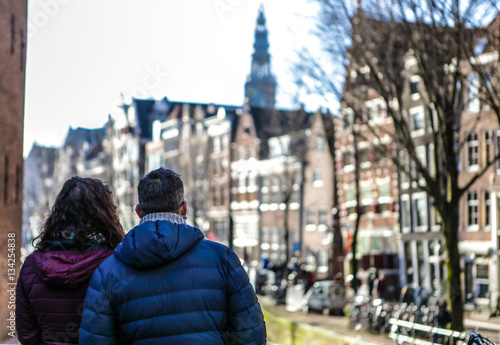 Photography Adult couple of tourists observing beautiful Amsterdam city.